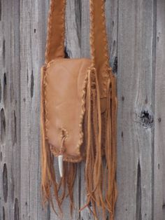 A fringed leather handbag. This bag is made in soft saddle colored leather and measures 8.5 inches tall, 6 inches wide and 2.5 inches deep. It has an extra pocket inside, a pocket outside on the back and an antler tip closure. The comfortable strap is 48 inches. We can make the strap any length you like. Just let us know... This item is MADE TO ORDER. Please read our policy on made to order items. Made to order items: Please allow 3 to 4 weeks to ship, sometimes sooner. You will not receive the Leather Satchel Bag With Fringe, Leather Satchel With Tassels, Rectangular Leather Shoulder Bag With Fringe, Leather Fringe Satchel Shoulder Bag, Leather Fringe Satchel For Everyday, Everyday Leather Fringe Satchel, Leather Shoulder Bag With Fringe For Daily Use, Brown Leather Shoulder Bag With Fringe, Brown Leather Fringe Shoulder Bag