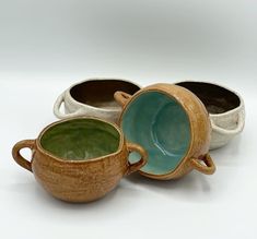 three ceramic cups sitting next to each other