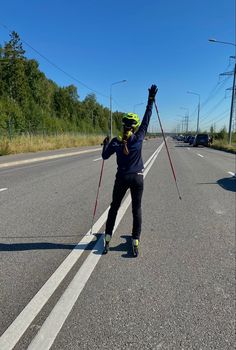 a person on skis is standing in the middle of the road with their arms up