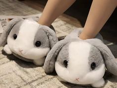 two stuffed animals sitting on top of a carpet next to each other in slippers