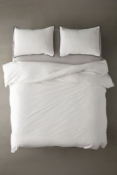 two white pillows on top of a bed