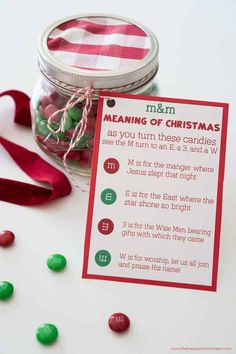 a jar filled with candy next to a red and white striped christmas tag that says meaning of christmas