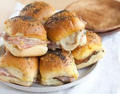 ham and cheese sliders on a plate next to a wooden spoon