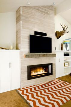 a living room with a fire place in the center and a television on top of it