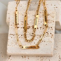 Our Engraved Name Necklace lets you wear your loved ones close. Choose one or more name bars, each engraved on both sides. Pick your chain style: curb or paperclip, available in 14", 16", or 18" lengths, plus a 2" extender. Made from stainless steel with 18k gold PVD plating or a silver finish, this necklace is waterproof and tarnish-free/ Material: Stainless Steel  Finish: Silver and 18k Gold PVD Plated Chain Type: Dainty Paperclip & 3mm Curb Chain Length: 14", 16" and 18" + 2" extender Number Gold Name Plate, Family Necklace, Jewelry Card, Bar Bracelets, Name Bracelet, Pitcairn Islands, Cayman Islands, Curb Chain, Guinea Bissau