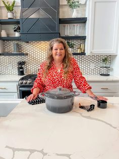 a woman standing in front of a pot on top of a kitchen counter