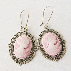 Lady silhouette cameo earrings. This lovely yet rose cameo earrings are just divine. This lovely piece of jewelry measures to fit a 25x18 mm cameo and comes with great antique toned french hook style dangle earrings. These gorgeous earrings measure 1 3/4 inches in length and would be the perfect gift for you or someone special. Cameo necklace: https://www.etsy.com/listing/500220724/pink-cameo-necklace-silver-letter?ref=shop_home_active_9&pro=1&frs=1 Cameo bracelet: https://www.etsy.com/listing/6 Antique Cameo Earrings Gift, Antique Cameo Earrings As Gift, Antique Cameo Earrings For Gift, Vintage Cameo Drop Earrings, Victorian Cameo Earrings For Gift, Cameo Earrings For Gift, Cameo Brass Jewelry, Brass Cameo Jewelry, Antique Pink Earrings Gift