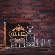 an old fashioned bottle and glasses are sitting on a table next to a wooden box