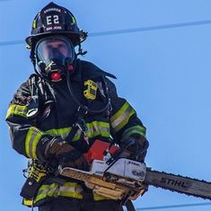 a fireman holding a chainsaw in his hands