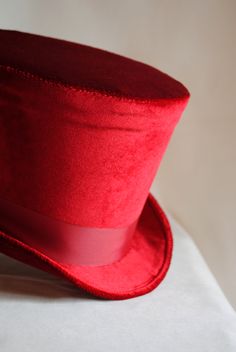 The Dandy is a simple and yet elegant victorian inspired top hat.It is covered with soft rich velvet in wine red.It is elegantly embellished with matching colored ribbon around the crown. Available in black, red(pictured) or ivory with matching ribbon. Need this TOP HAT in another color? with more decoration? Just send me a message to talk about a custom hat made just for you! This hat is fully lined with satin and it is made to according to your exact head measurement making it suitable for bot Red Brimmed Hat For Costume, Red Costume Hat, Red Fitted Hat For Costume, Red Fitted Vintage Top Hat, Vintage Red Hat For Costume Party, Vintage Red Hats For Costume Party, Classic Red Fitted Top Hat, Red Fitted Top Hat For Winter, Vintage Red Brimmed Top Hat