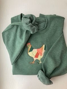 Your favorite cozy chicken sweater made of a patchwork style fabric. Please note that each sweater is unique based on how the fabric is stitched. Fall Cotton Patchwork Sweater, Patchwork Cotton Sweater For Spring, Cozy Cotton Sweater With Patchwork, Cute Green Cotton Sweater, Cozy Cotton Patchwork Sweater, Cute Patchwork Tops For Fall, Green Cotton Patchwork Sweater, Multicolor Cotton Sweatshirt For Fall, Winter Cotton Sweatshirt With Patches