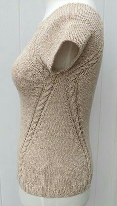 a white mannequin wearing a beige sweater with an open back and zippers