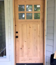 the front door is made from wood and glass