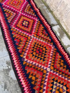 a multicolored rug is laying on the ground