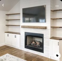 an empty living room with a fireplace and shelves on either side of the fire place