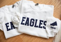 Custom Cheerleader Sweatshirt Cheer Sweatshirt Puff Print Embossed Print Gift for Cheerleader Christmas Gift Idea School Spirit Sweatshirt ADD SLEEVE TEXT HERE : https://www.etsy.com/listing/1715269563/text-on-sleeve-upgrade The main listing image (EAGLES) is white sweatshirt, navy puff text CASE SENSITIVE For your order to appear like our listing photo, you must write your text to us IN ALL CAPS Example: EAGLES ... NOT Eagles. If its sent to us as 'Eagles', it will print this way    DETAILS White School Spirit Sweatshirt With Ribbed Cuffs, White Sweatshirt With Ribbed Cuffs For School Spirit, White Tops With Team Spirit For Winter, White School Spirit Tops With Letter Embroidery, White Varsity T-shirt For Winter, White Tops With Letter Embroidery For School Spirit, White School Spirit T-shirt For Winter, Long Sleeve Top With Letter Embroidery For Game Day, Cheer Sweatshirts Design