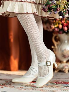 a close up of a woman's legs wearing white shoes