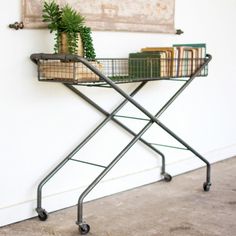 a metal table with a basket on it and some books sitting on top of it