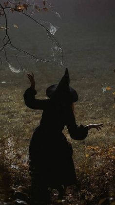 a person standing in the grass with their hands out to catch some raindrops