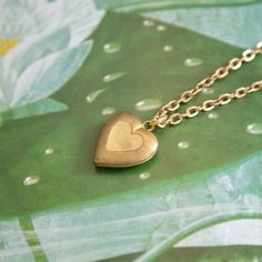 Deadstock vintage simple, small brass heart locket charm on a gold-plated cable chain. 16" Length chain 16.5mm by 14mm charm Vintage Heart Pendant Locket Necklace With Adjustable Chain, Vintage Everyday Heart Pendant Jewelry, Dainty Brass Locket Charm Necklace, Vintage Heart Locket Necklace With Adjustable Chain, Gold Brass Heart Charm Necklaces, Gold Brass Charm Necklace With Heart Charm, Classic Gold Charm Necklaces For Valentine's Day, Gold Heart Necklace With Vintage Charm For Gift, Gold Brass Dainty Locket Necklace