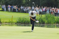 a man holding a golf racquet on top of a green