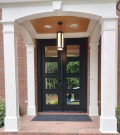 an entry way with two doors and brick walkway