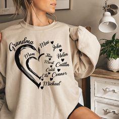 Personalized New Grandma Sweatshirt, Grandma Heart Sweat, Christmas Gigi Tee-shirt, Abuela T-shirt, Grandkids Name Shirt, Gift For Grandma, Nana Crewneck, Holiday Winter Shirt, Valentines Gift for Grandma You are welcome to Tabithas Fashion store! I'm here to help you to have a good shopping experience as much as I can. If you have any request (more size and color options) please feel free to message me. I will reply as soon as possible. * Please note: This design will be made with Direct To Fabric print (DTF). * I have listed some information to help you below: - Price is for 1 shirt. 𝑶𝑹𝑫𝑬𝑹𝑰𝑵𝑮 𝑰𝑵𝑭𝑶 1- Please check all the photos from the listing. 2- Please choose your T-shirt, Sweatshirt, or Hoodie size and color. (T-shirt, Sweatshirt, or Hoodie sizes are shown on the listing Long Sleeve T-shirt For Mother's Day, Casual Heart-shaped Top With Name Print, Casual Tops With Heart Shape And Name Print, Mother's Day Crew Neck Top With Heart Graphic, Family Long Sleeve T-shirt For Mother's Day, Long Sleeve T-shirt For Mother's Day Family Event, Personalized Long Sleeve T-shirt For Mother's Day, Customizable Long Sleeve Family Matching T-shirt, Long Sleeve T-shirt With Heart Graphic For Gift