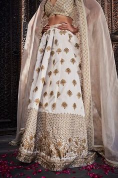 Ivory silk lehenga with an attached cancan and gold floral embroidery. Comes with a padded blouse and a dupatta.
Components: 3
Pattern: Embroidered
Type Of Work: Floral
Neckline: Deep V Neck
Sleeve Type: Sleeveless
Fabric: Silk
Color: Ivory
Other Details: 
Attached lining
Product Weight: 2 Kgs
Occasion: Wedding - Aza Fashions Semi-stitched Silk Lehenga With Gold Embroidery, White Anarkali Dress With Gold Embroidery, White Embroidered Raw Silk Gown, Silk Lehenga With Gold Embroidery In Traditional Drape, Reception Sharara With Gold Embroidery In Raw Silk, Raw Silk Sharara With Gold Embroidery For Reception, Floor-length Raw Silk Sharara With Gold Embroidery, Designer Raw Silk White Gown, Silk Dupatta With Gold Embroidery For Reception