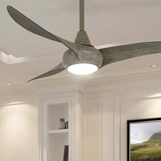 a ceiling fan mounted to the side of a wall in a room with white walls