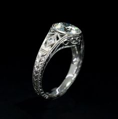 an antique style diamond engagement ring with filigrees