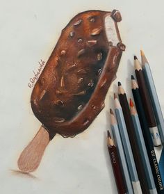 some colored pencils are next to a drawing of a chocolate ice cream cone with sprinkles