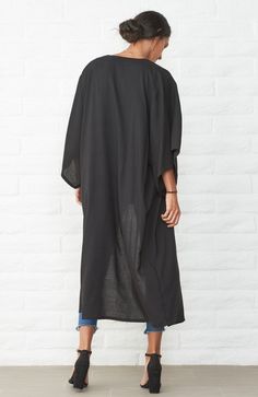 Eco friendly caftans and tunics inspired by the ocean, made on main street. Ethically sourced and locally made in Los Angeles. When we travel, we want clothes that take up minimum space but do maximum work. Meet the Kimono Wrap Duster in Black. It's a dress. It's a duster. It's a robe. It's a cover-up. This one does it all and we couldn't be happier! As a dress, two discreet buttons keep the wrap securely in place and give the dress an architectural drape. The removable self-tie belt can be add Casual Black Cover-up For Loungewear, Oversized Black Beachwear Cover-up, Oversized Black Cover-up For Vacation, Black Long Kimono For Beach Cover-up, Casual Black Kimono For Beach Cover-up, Oversized Black Beach Cover-up, Oversized Black Cover-up For Beach, Oversized Black Bohemian Cover-up, Casual Black Long Cover-up