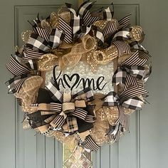 a wreath that says welcome hanging on the front door with burlocks and bows