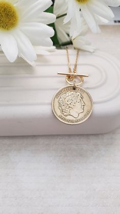 This authentic and vintage Greek coin makes a fabulous gold medallion necklace. It is a   100 or 50 drachma coin set on an 18" gold-plated chain. Your choice of a front toggle closure or a back lobster clasp with a 3" chain extender. The coin has been polished and matches the chain beautifully. Welcome to Recycled Finery!  I repurpose old jewelry, coins, beads, vintage buttons, watch parts, and charms into new jewelry.  My ever-growing collection of these materials comes from estate sales, rumma Nickel-free Yellow Gold Medallion Coin Necklace, Gift Medallion Necklace With Coin Pendant, Nickel-free Coin Medallion Necklace Gift, Classic Coin Pendant Necklace As Gift, Classic Medallion Necklace With Coin Pendant As Gift, Vintage Style Coin Pendant Necklace As Gift, Gold Coin Necklace Nickel Free, Classic Tarnish Resistant Coin Necklace For Gift, Classic Tarnish-resistant Coin Necklace For Gift