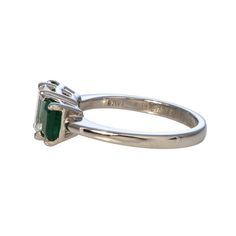 This three-stone engagement ring features an emerald-cut diamond center flanked by a pair of emerald-cut emeralds prong-set in a platinum mounting. Center Diamond Total Weight: 1.13 ct Shape: Emerald-Cut Color: F Clarity: SI1 Side Emerald Total Weight: 1.08 ct Shape: Emerald-Cut Color: bluish-green hue, medium dark tone, strong to vivid saturation Clarity: slightly included Ring Size: 7 Excluded from all discounts and promotions. Circle Monogram, Platinum Engagement Rings, Three Stone Engagement, Bluish Green, Three Stone Engagement Rings, Stone Engagement, Platinum Ring, Emerald Cut Diamonds, Hand Engraving