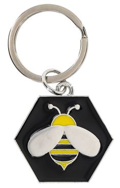 a keychain with a bee on it and a black hexagonal background