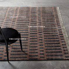 a chair sitting on top of a rug next to a black chair and white table