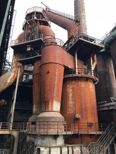 an industrial factory with large brown pipes and smokestacks on the building's side