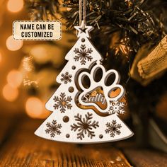 an ornament shaped like a christmas tree with a dog's paw on it