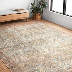 a large area rug in a room with wooden floors and white walls, along with a window