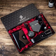 an assortment of men's accessories in a gift box on a wooden table top