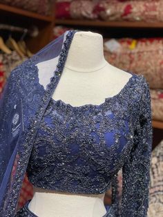 Midnight blue craftsmanship with fine details of beads, stone, thread and cutdana nestled on silk fabric in floral embroidery bloom this lehenga. Includes a ready long sleeves blouse paired with beautiful net dupatta. If you are planning to ace the grace of your D-day dress, then this Midnight Blue is the best choice. Fabric: Net Size: 38/M Occasion: Wedding Ceremony or Reception WASH CARE INSTRUCTIONS - Please Dry clean only when it is applicable. Slight color variation is possible due to digit Party Wear Choli With Intricate Embroidery And Long Sleeves, Party Wear Long Sleeve Choli With Intricate Embroidery, Long Sleeve Choli With Intricate Embroidery For Party, Long Sleeve Organza Choli With Zari Work, Party Wear Long Sleeve Choli For Wedding, Long Sleeve Organza Choli With Resham Embroidery, Organza Lehenga With Sheer Dupatta, Organza Lehenga With Sheer Dupatta And Long Sleeves, Long Sleeve Lehenga With Sheer Dupatta In Organza