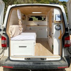 the back end of a van with an open bed and storage compartment on it's side