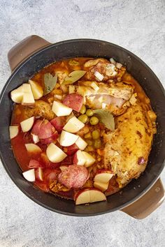 a pan filled with meat and vegetables on top of a table