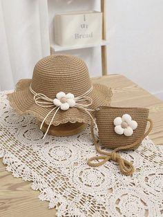 two hats are sitting on top of a doily with white flowers in the center