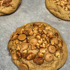 three cookies with nuts on top sitting on a table