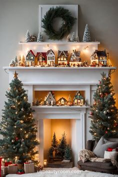 a fireplace decorated for christmas with lit trees and small houses on the mantels