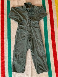 "Vintage 70s/80s military coveralls. OG 107 cotton sateen. Made in USA. In good vintage condition. Has some holes and stains throughout, tried to show in photos. Lots of cool mending. If you don't liked the trashed look then these are not for you. Great fade and patina. Adjustable at the waist and ankles. Tags missing. Size marked with a marker, \"M\" but please refer to the actual measurements: 23 inches from pit to pit measured lying flat, 18 inches across the shoulders, 17 inches across the w Military Style Cotton Overalls, Military Style Long Sleeve Cotton Jumpsuit, Military Style Long Sleeve Cotton Jumpsuits And Rompers, Khaki Cotton Long Sleeve Jumpsuits And Rompers, Vintage Green Cotton Jumpsuits And Rompers, Vintage Washed Cotton Overalls, Vintage Long Sleeve Jumpsuits And Rompers For Fall, Vintage Jumpsuits And Rompers For Fall, Coverall Men