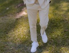 a man in a suit and tie standing on the grass