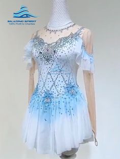 a white and blue dress with sequins on the neckline is displayed in front of a mannequin's head